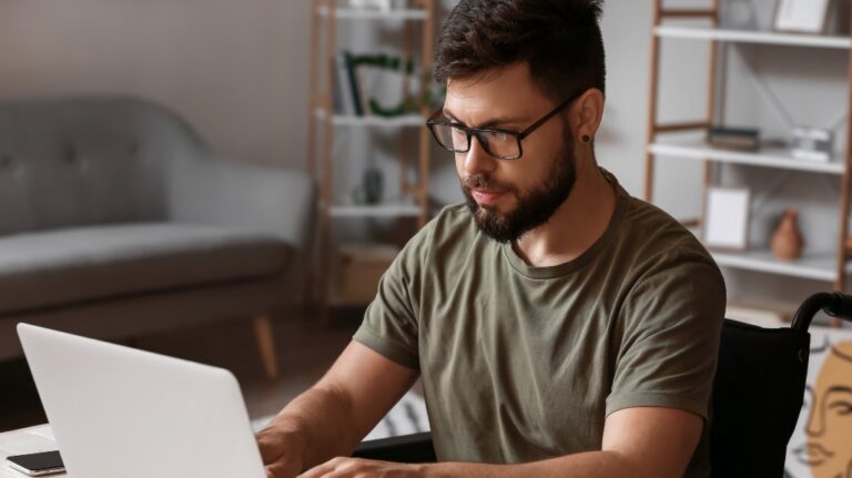 Soldier in wheelchair using laptop at home