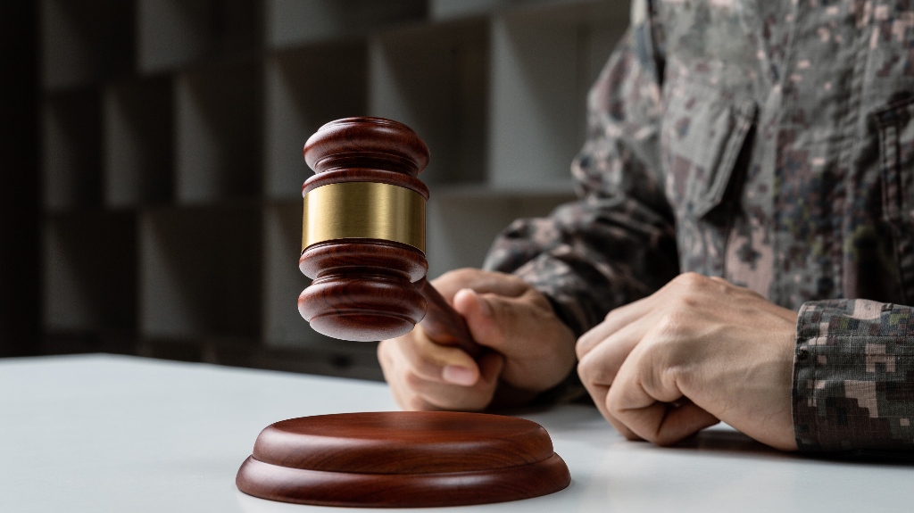 Hand of soldier holding gavel